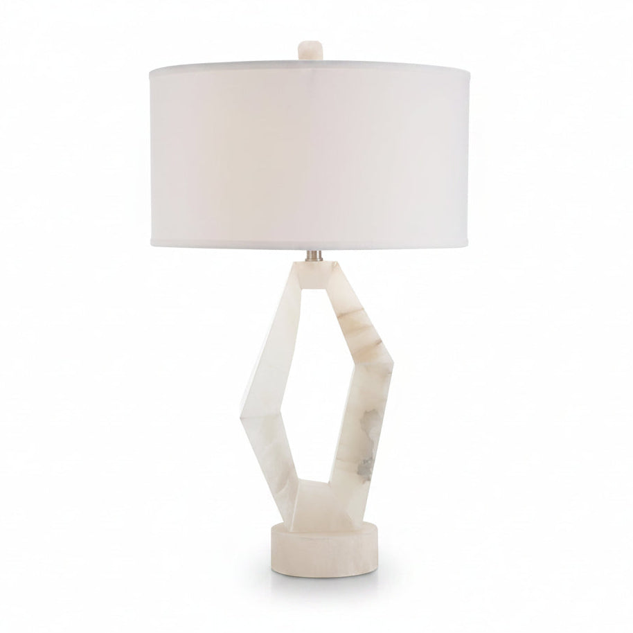 Table lamp with a white geometric base and a round beige lampshade on a white background