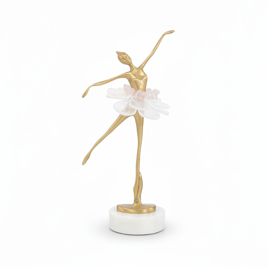 Gold dancer figurine with a white flower on a marble base against a white background