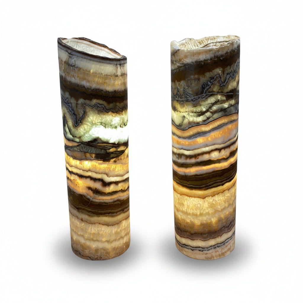 Two cylindrical stone lamps with layered patterns on a gray background