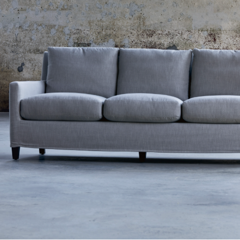 Gray sofa in a room with brick walls and wooden doors.