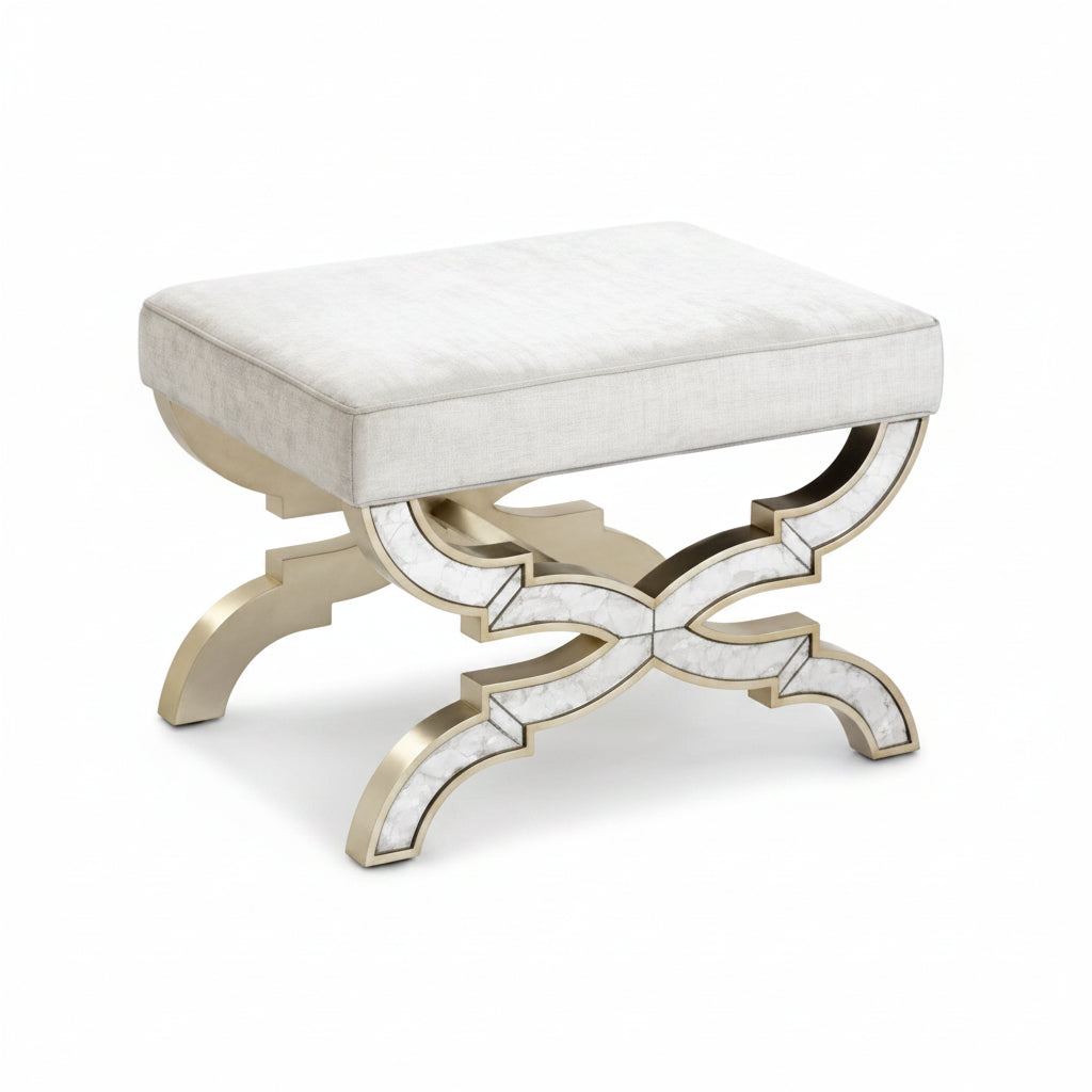Decorative stool with a white cushioned seat and gold metal base on a white background