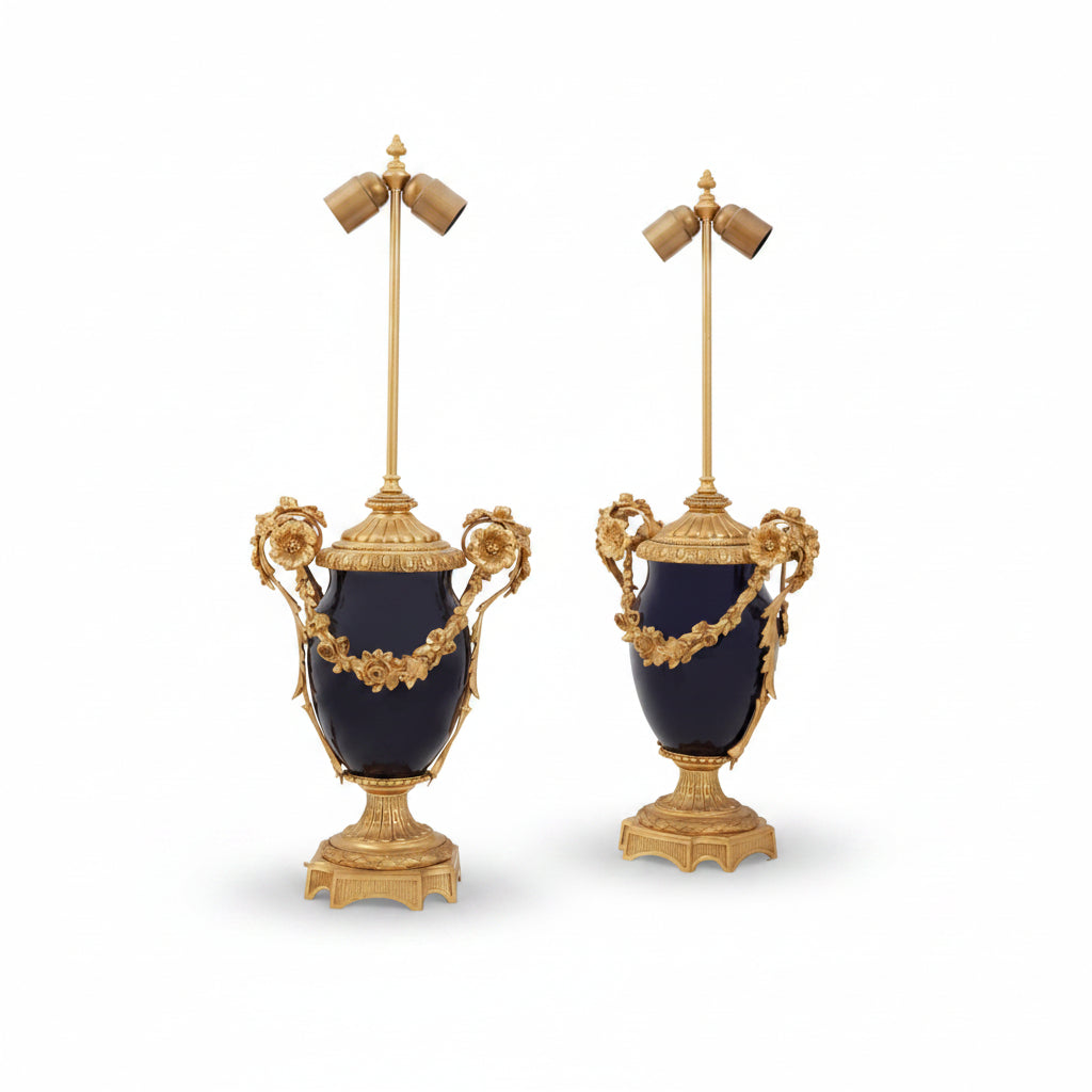 Pair of ornate lamps with gold detailing and blue urns on a white background