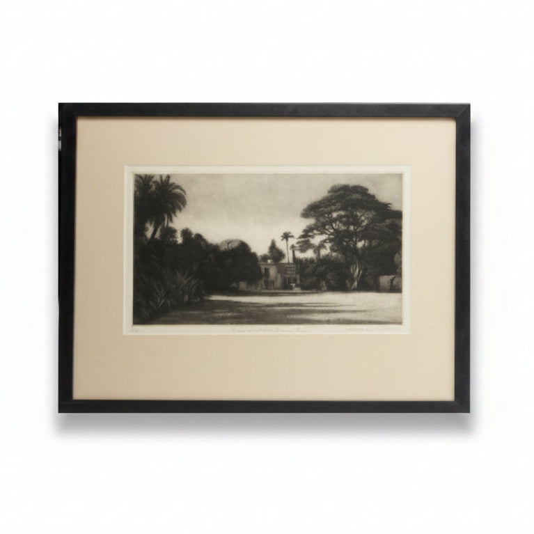 Framed black and white photograph of a garden scene with trees and a building.