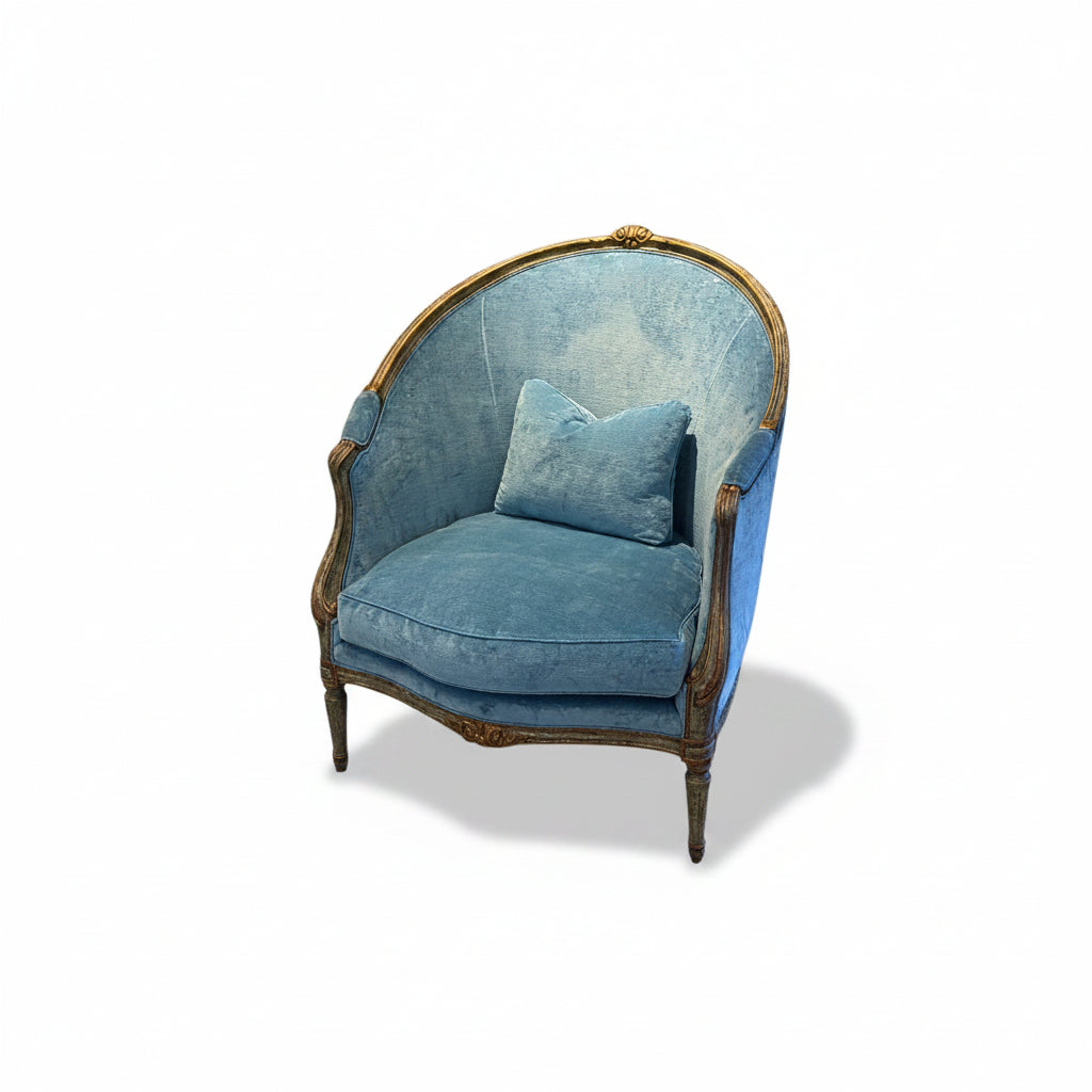 Blue velvet armchair with gold accents on a white background